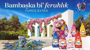 Yumoş Extra kumaş yumuşatıcı ürünlerinin yanında parkta birlikte oturan iki ayı.