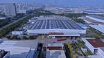 Çin'deki Unilever'in Hefei fabrikasının, çatısında güneş panelleri bulunan bir görüntüsü. Arka planda şehir görünüyor.